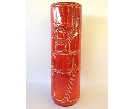 A tall cylindrical Poole Pottery carved Delphis vase, shape 85, decorated in a red glaze (15.5 inches).