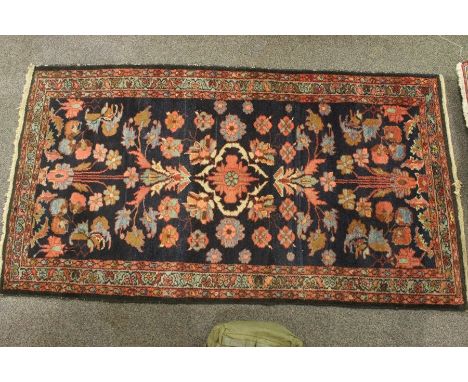 Two woollen rugs, the first approx 193 x 104 cms, with a central foliate design with border surround, peach, green and blue c