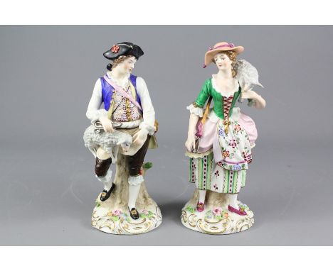 Two Sitzendorf figurines; the first being a shepherdess carrying a lamb on her shoulder, approx 20 cms h, (hairline crack to 