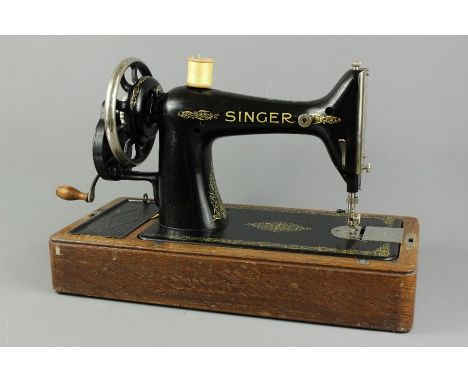 A vintage sewing box, complete with an array of contents together with a Singer sewing machine. (2)
