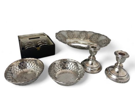 A group of silver items comprising of a pair of candlesticks, a pair of toast racks, two bowls and a bread basket

The candle