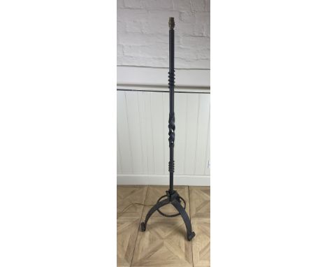 A wrought iron standard lamp
With pierced spiral turned stem on tripod legs and scroll feet, 143cm high including fittings.