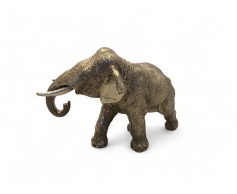 A silver model Asian elephant in walking pose,&nbsp;Carrs of Sheffield Ltd, Sheffield,1999&nbsp;
25cm wide. (Filled)