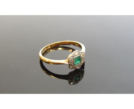 An emerald and diamond set floral ring, the centre square cut emerald framed by small diamonds, stamped 18ct. Pt. Size K, 1.8