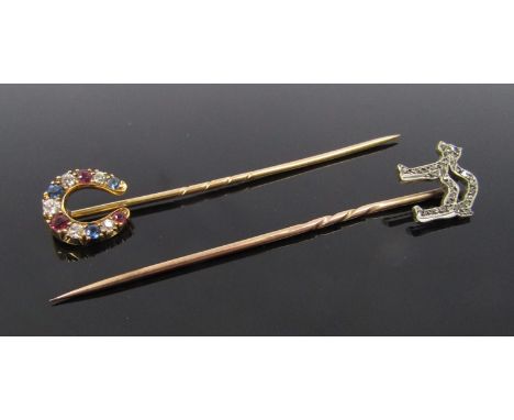 Two gold stick pins one as a diamond studded cat (no tail) and a diamond, ruby and sapphire horseshoe, 3.9g