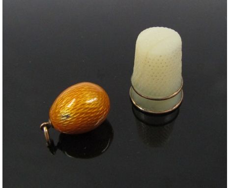 An enamel egg pendant, unmarked 4.6g (slight damage to enamel) with a mother-of-pearl thimble