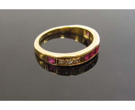 A gold diamond and ruby half hoop ring, stamped 18c. Size P, 4.4g