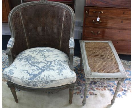 A Louis XVI style carved grey painted bergere, first half 20th century, with double caned curved back and single caned seat, 