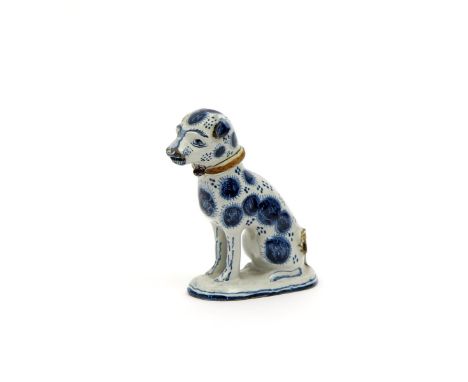 A delftware model of a dog, dated 1761, seated on its haunches on an oval pad base, its head slightly turned, the coat decora