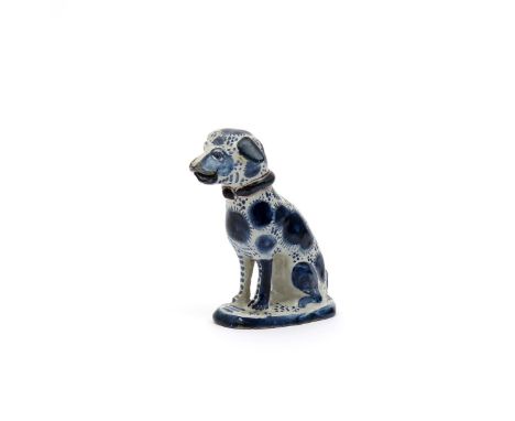 A delftware dog moneybox, dated 1756, seated on its haunches on an oval pad base, its coat decorated with blue wheels of fire
