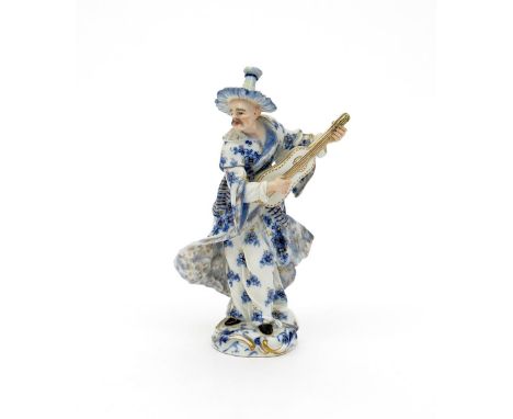 A Meissen figure of a Malabar musician, 19th century, playing a stringed instrument and wearing a blue flowered costume, blue