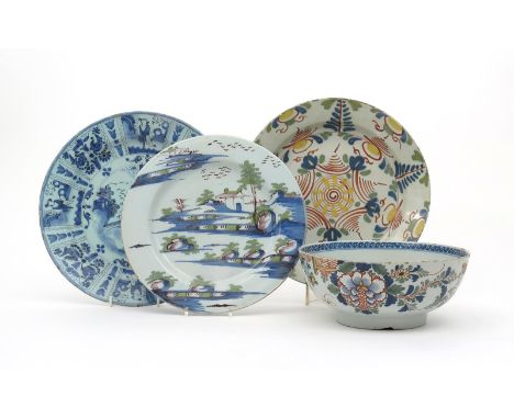 Three delftware chargers, 18th century, one painted in blue, green and manganese with a landscape, another in polychrome enam