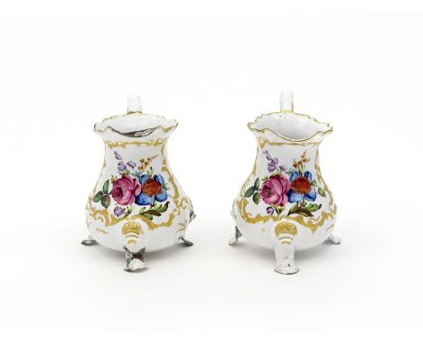 A pair of English enamel small jugs, c.1770, painted in bright colours with panels of flowers within rococo scroll borders, r