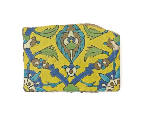 An Islamic cuerda seca tile fragment, probably 17th century, decorated with an Iznik style design of geometric flowerheads an