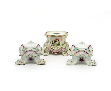 A pair of Chelsea tripod stands, c.1760, a bunch of grapes hung between each scrolling foot, the top of which terminates in a