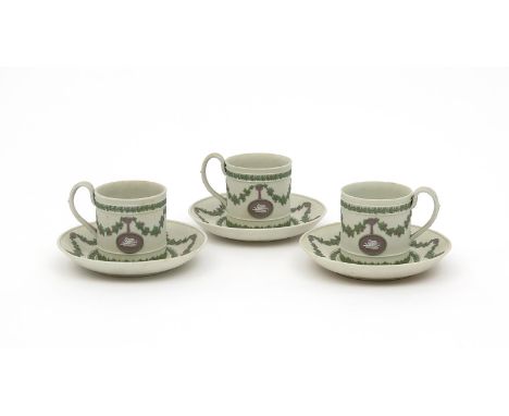 Three Wedgwood tricolour Jasperware coffee cans and saucers, 19th century, the cans applied with small plaques of putti suspe