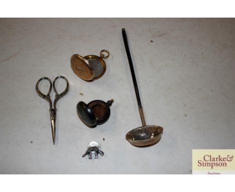 A small white metal toddy ladle with whalebone twist handle; gun metal sovereign case; a yellow metal locket etc.