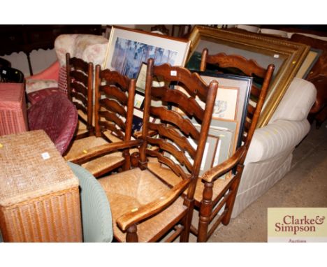 A set of six elm ladder back and rush seated dining chairs, four standards, two carvers 