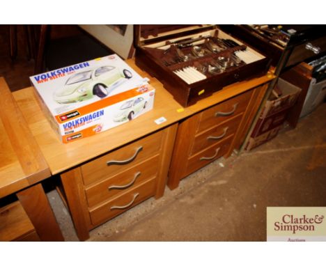 A pair of light oak three drawer bedside chests 