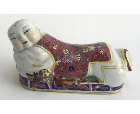 A miniature Chinese ceramic pillow, in the form of a recumbent gentleman, 14.5cmL 