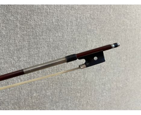 An early 20th Century violin bow, ebony frog, round stick, mother of pearl inlay and white metal mounts. Ivory license refere