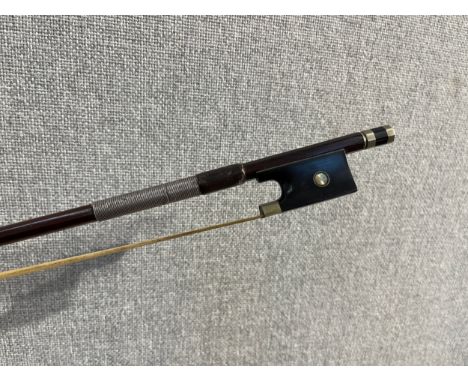 An early 20th Century violin bow, ebony frog, round stick, mother of pearl inlay and plated metal mounts. Ivory license refer