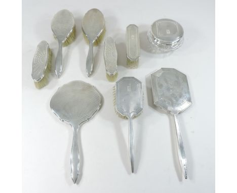 An Art Deco silver dressing table set, together with another set, to include a trinket jar