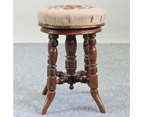 A Victorian walnut and tapestry upholstered revolving piano stool