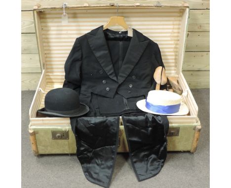 A canvas and wooden bound travelling trunk, containing a tailcoat, bowler hat and straw boater