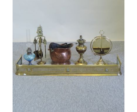 An Edwardian brass fender, together with fire tools, oil lamps and a brass gong 