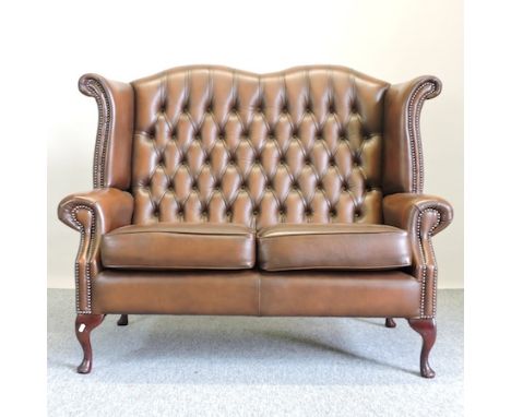 A brown leather upholstered button back wing sofa, 134cm 