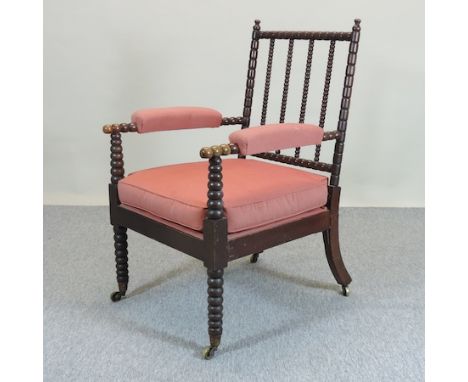 A Victorian upholstered bobbin turned armchair, with a red cushion seat