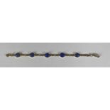 9CT GOLD LAPIS LAZULI BRACELET, flat link and set with five oval shallow cabochon cut stones with
