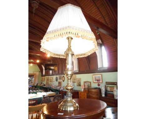 A cotemporary brass standard lamp with pleated silk tasselled shade.