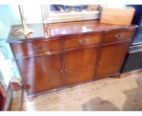 A mahogany veneered sideboard, the rectangular top over three frieze drawers and three cupboard doors on bracket feet.