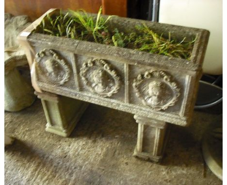 A reconstituted stone garden planter of rectangular form, cast with profile reserves on twin end panelled supports, 70cm.