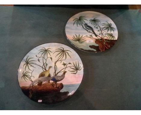 A pair of early/mid-20th century Continental ceramic wall plates, each hand decorated with exotic birds and seascape, 34.5cm 