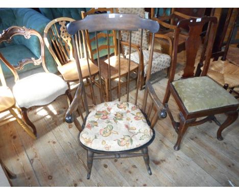 A reproduction stained beach stick back rocking chair.