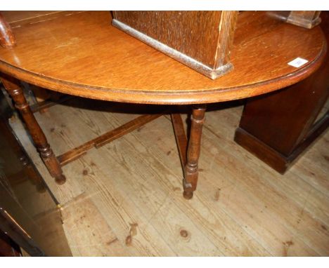 An early 20th century oak drop leaf gate leg dining table on turned and block supports.