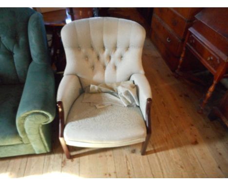 A modern button upholstered armchair, covered in pale blue fabric.