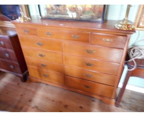 A modern veneered chest, the rectangular top over three frieze drawers and eight further drawers on bracket feet, 144cm wide.