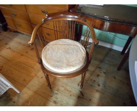 An Edwardian armchair, having bow back, pierced and stick splat, over-stuffed seat on turned reeded tapering forelegs.