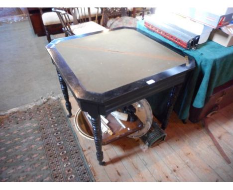 A late 19th century ebonised card table with foldover top on turned legs.