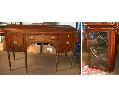 An Early 19th Century Mahogany Bowfront Sideboard, the central drawer flanked by twin cellarette drawers, gilt-metal hoop han