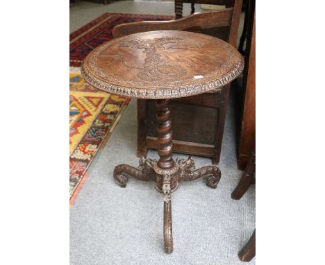 A 19th Century Carved Oak Tripod Table, the later circular top carved with a dragon holding a shield bearing a monogram, on a