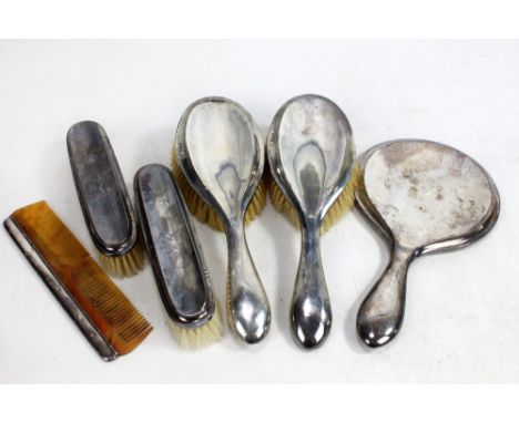 HENRY MATTHEWS; a George V hallmarked silver backed six piece dressing table set comprising a circular hand mirror, length 25