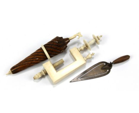 &nbsp;An ivory sewing clamp, a wooden and bone needle case modelled as an umbrella and a base metal trowel bookmark (3).&nbsp