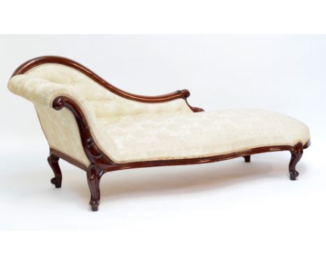 A Victorian mahogany chaise longue with button cream upholstery, carved foliate scroll detail and raised on cabriole supports