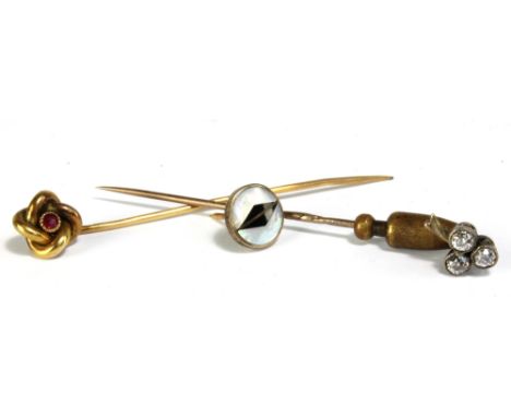 A yellow metal and diamond tie pin modelled as a trefoil set with three round cut stones, each weighing approx 0.2ct, and a f