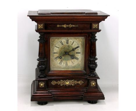 A German mahogany cased mantel clock, the dial set with Roman numerals and flanked by turned columns, bearing paper label ins